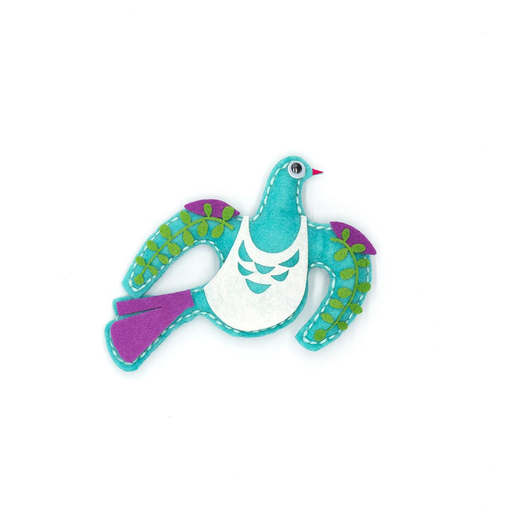 A colorful bird brooch made with our Kereru Felt DIY Kit features a turquoise body, white belly, purple tail, and green leaf-patterned wings—an adorable, creative accessory ideal for heartfelt gifts.