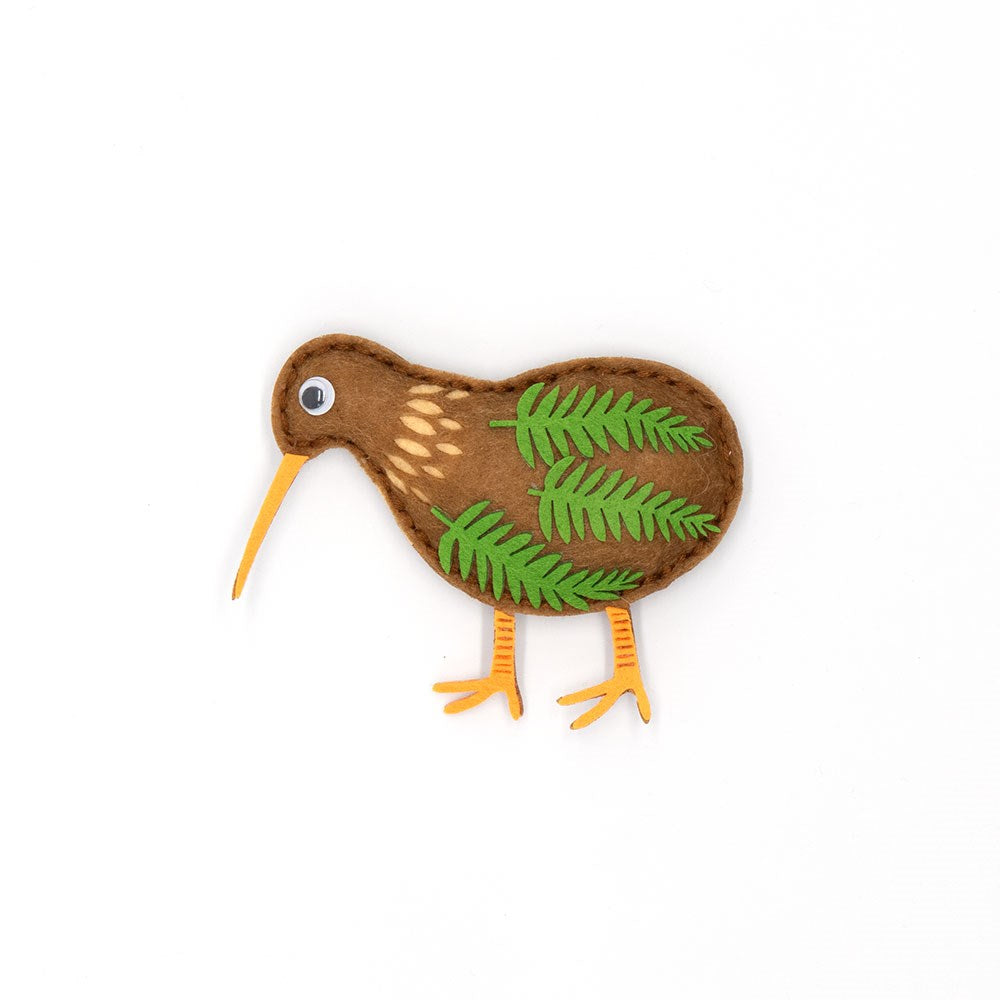 The Kiwi Felt DIY Kit features a handmade felt kiwi bird with a brown body, green felt wing leaves, yellow beak and legs, plus a googly eye—ideal as a heartfelt gift or creative project. Shown on a plain white background.