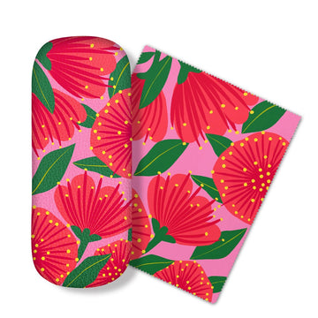The Bright Botanical Pink Pohutukawa Glasses Case comes with a matching microfibre cloth, both featuring large red flowers with yellow dots and green leaves on a pink background. Ideal for cleaning screens and protecting your glasses.