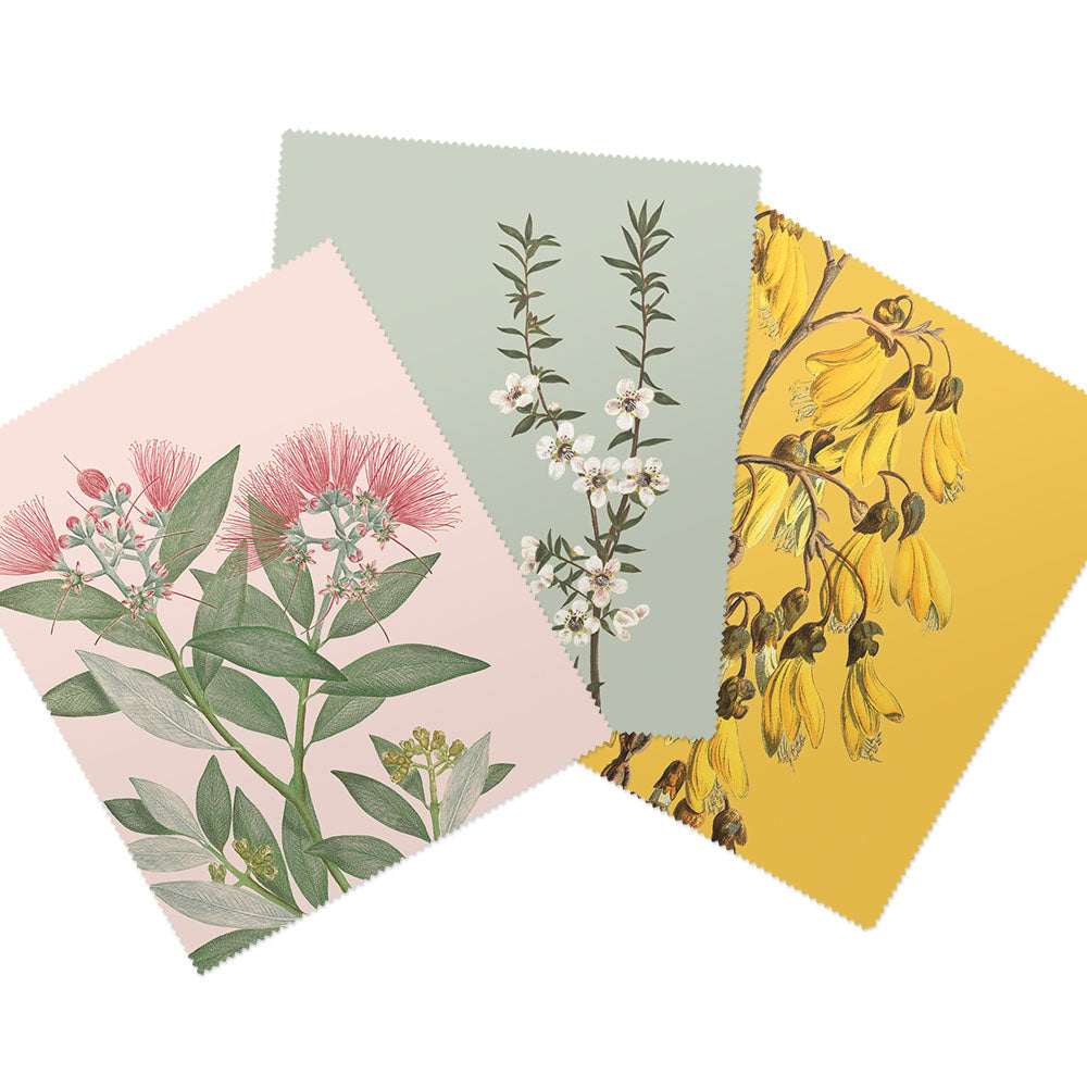 The Set of 3 Vintage Botanical Collection Lens Cloths features pink and green blooms, white flowers on pale blue, and yellow florals—each design inspired by New Zealand flora.