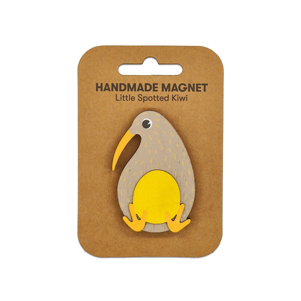The Little Spotted Kiwi Wooden Magnet is a handmade wooden magnet shaped like a kiwi bird, attached to brown packaging labeled Handmade Magnet Little Spotted Kiwi with a hanging slot. Part of our charming Aotearoa Magnets collection.