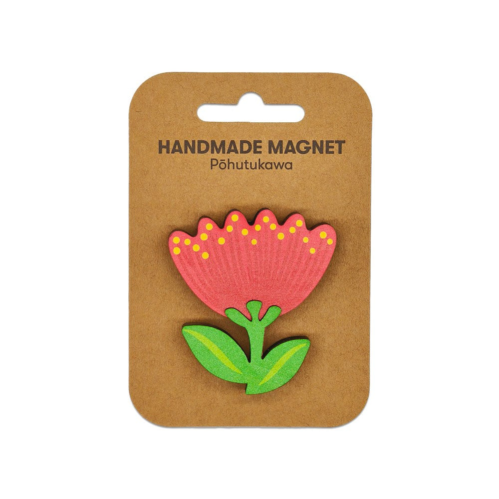 The Pohutukawa Wooden Magnet is a handmade Kiwiana piece featuring a stylized red pōhutukawa with yellow dots and green leaves, displayed on a brown card labeled HANDMADE MAGNET Pōhutukawa—a unique memento from Aotearoa.