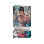The Nymph Pocket Mirror features art inspired by The Nymph: a woman in red bikini bottoms, waist-deep in water, covering her chest amid trees and sky. A metallic strip at the bottom nods to J.H. Lynch’s iconic print style.