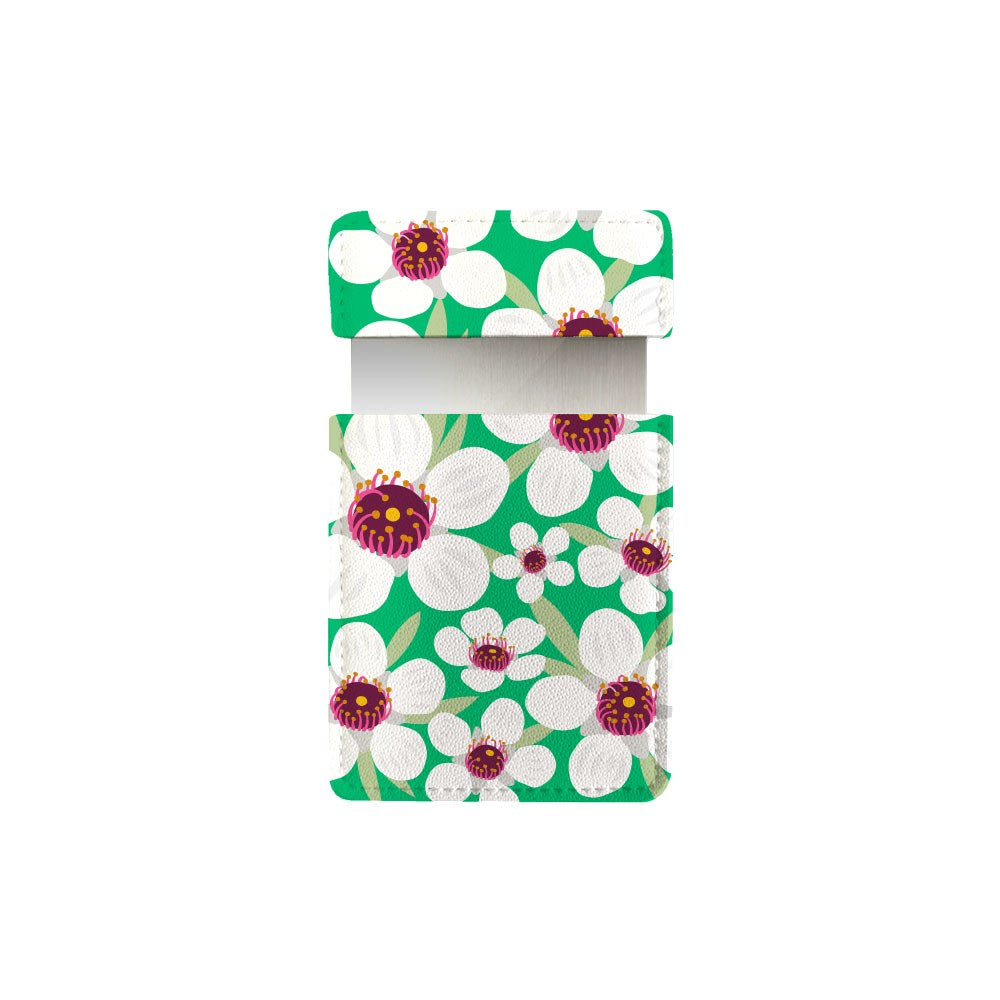 The Bright Botanical Manuka Pocket Mirror features bold Vintage Bright Botanicals—large white flowers with purple and yellow centers—for a stylish, nature-inspired accessory.