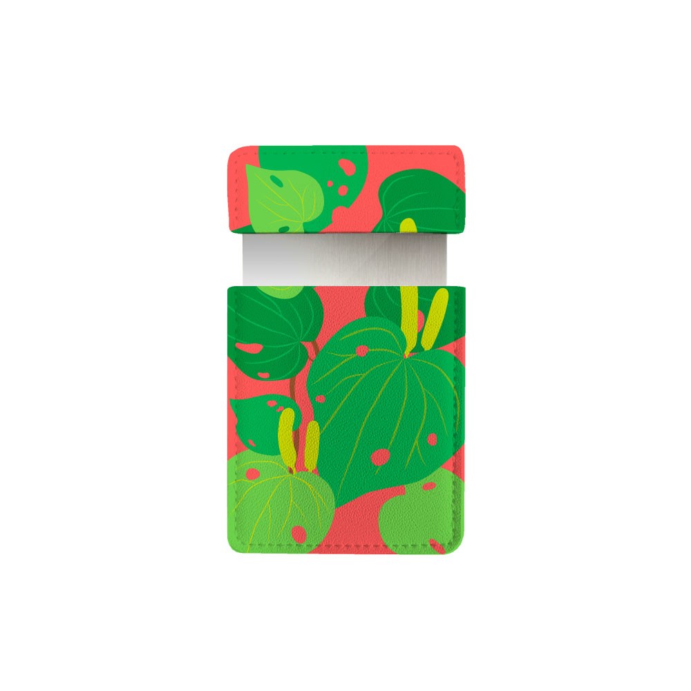 The Bright Botanical Kawakawa Pocket Mirror comes in a rectangular vegan leather case with a flip-top lid, showcasing green and yellow leaves on red. The interior is ideal for storing the pocket mirror.