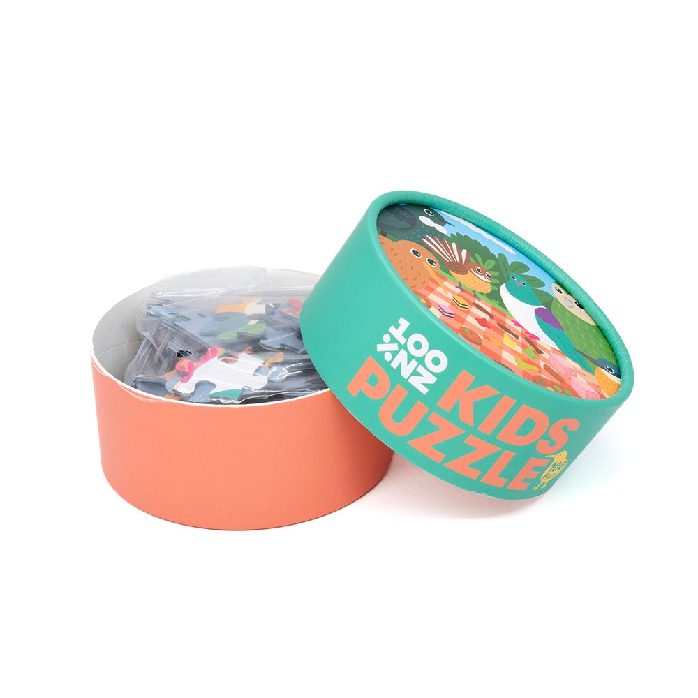 A round box labeled Picnic Tweets Kids Puzzle features a colorful illustration of New Zealand native birds on the teal lid. The orange-bottomed box is open, showing puzzle pieces inside a plastic bag.