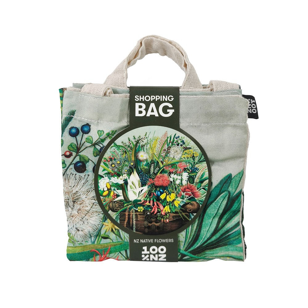 The NZ Native Flowers Shopping Bag is an affordable, reusable tote with a floral design and beige handles. It folds for convenience and features a label: “SHOPPING BAG NZ NATIVE FLOWERS.” Ideal for stylish, eco-friendly shopping.