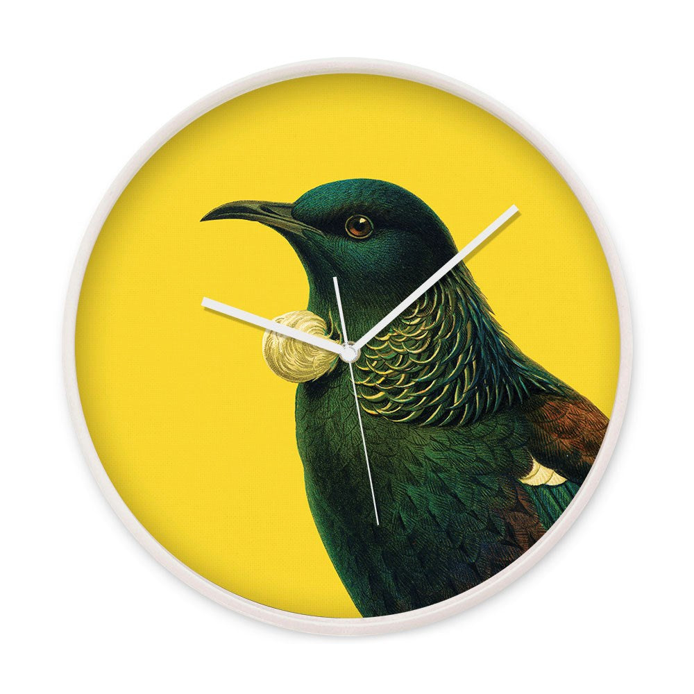 The Bright Tui Wooden Frame Clock features a vivid Tui bird design with iridescent green and blue feathers on a yellow background. It has silent movement, white hour, minute, and second hands, and comes with a sleek wooden frame.