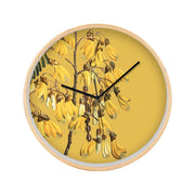 The Vintage Botanical Kowhai Wooden Frame Clock features a yellow background and a flowering kowhai branch illustration, with black hour and minute hands at 10:09 and no numerals on the round wooden clock face.