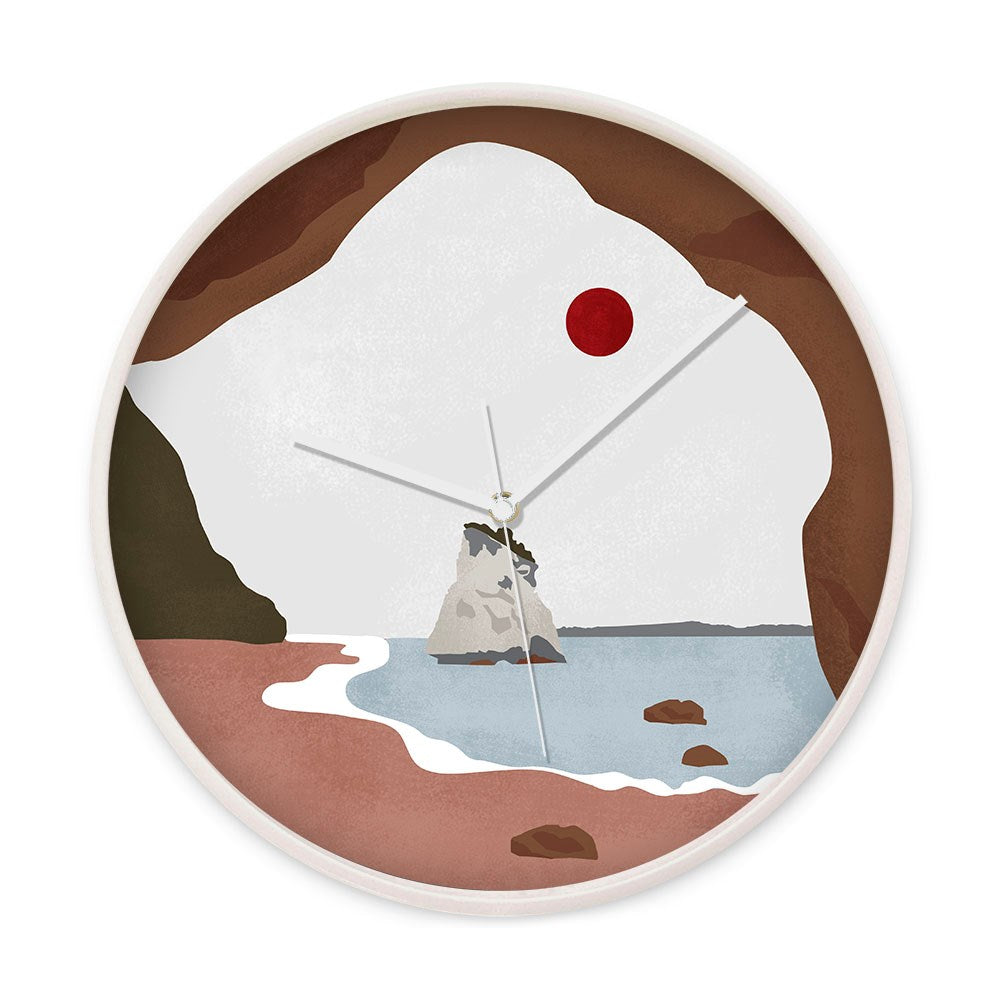 The Cathedral Cove Landmark Wooden Frame Clock features a beach scene with rocks, a cave arch, red sun, and soft earth tones. Its silent movement and white hands create a peaceful ambiance.