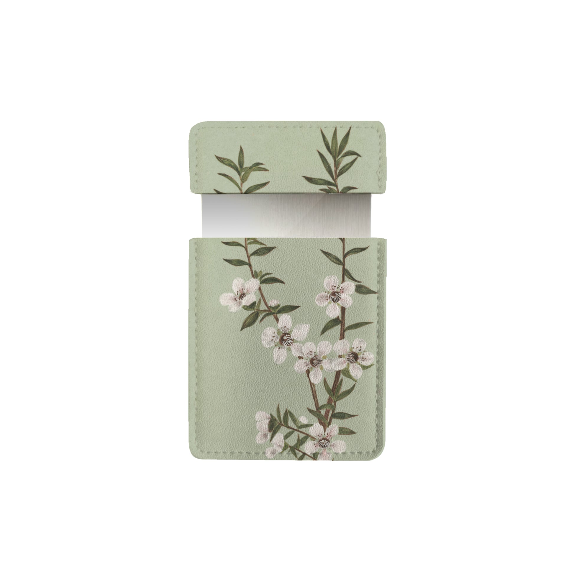A light green rectangular vegan leather Vintage Botanical Manuka Pocket Mirror case with a flap, featuring a branch of white flowers and green leaves, shown open with a white card partially visible inside.