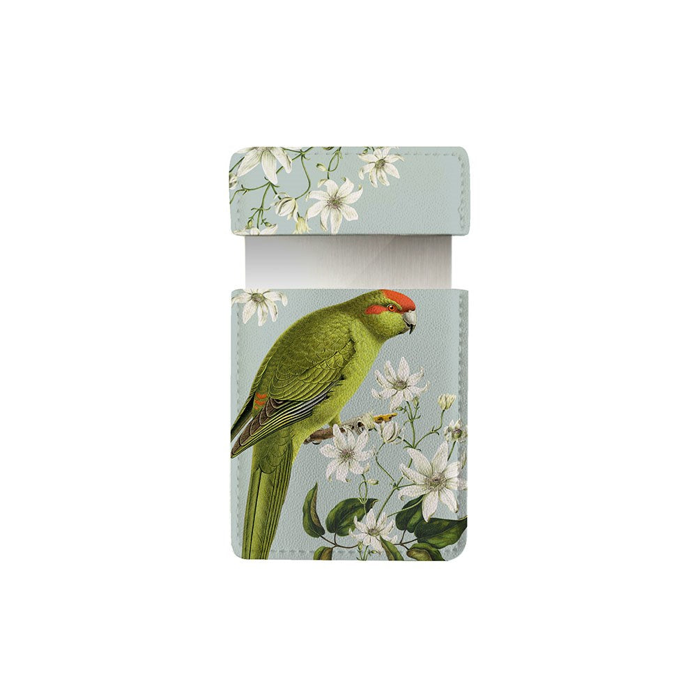 The Birds & Botanics Kakariki Pocket Mirror comes in a light blue vegan leather case, adorned with a green parrot and botanical motif, white flowers, and a flap closure—perfect as a stylish accessory for your handbag.