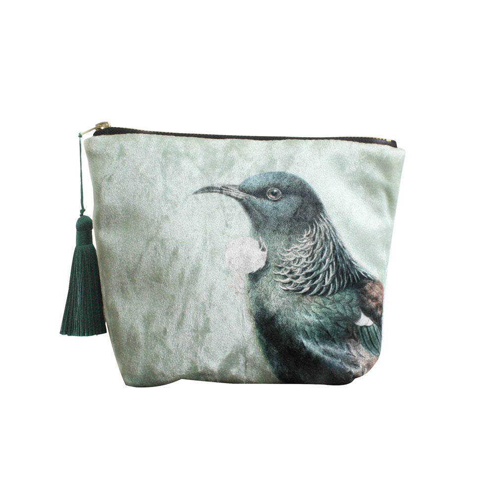 The Hushed Green Tui Velvet Cosmetic Bag features a zippered design with a dark green tassel and an illustration of a New Zealand tui with iridescent green and brown feathers—perfect as a unique gift.