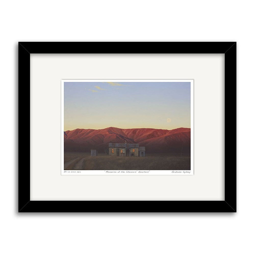 Grahame Sydneys Moonrise at the Shearers Quarters Small Art Print: Second Frame shows a house and sheds before red mountains at dusk with a full moon, beautifully presented in a white mat and black frame.