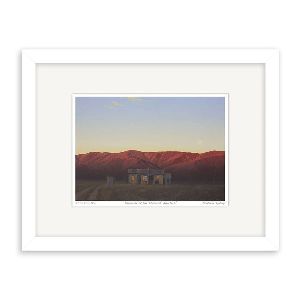 The Grahame Sydney - Moonrise at the Shearers Quarters Small Art Print: Second Frame features a lit house amid red hills at dusk with the moon above, presented with a white mat and simple white frame.