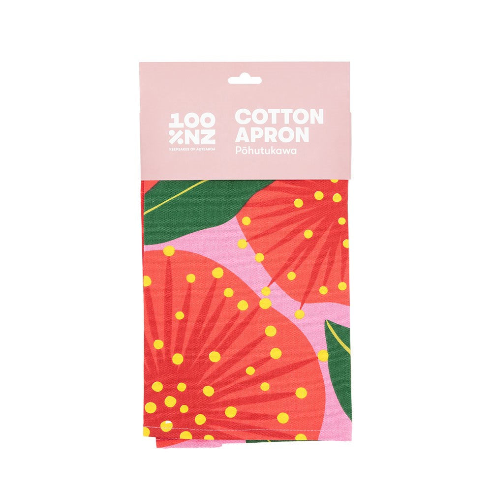 The Bright Botanical Pink Pohutukawa Apron is made from 100% NZ cotton and features a vibrant floral pattern with red and pink flowers and green leaves. The apron is labeled 100% NZ Cotton Apron Pōhutukawa and designed in New Zealand.