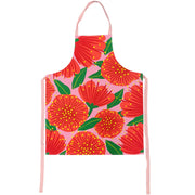 The Bright Botanical Pink Pohutukawa Apron features large red flowers, green leaves, and yellow dots. Made from 100% cotton with a neck loop and two side straps, it’s designed in New Zealand for both style and comfort.