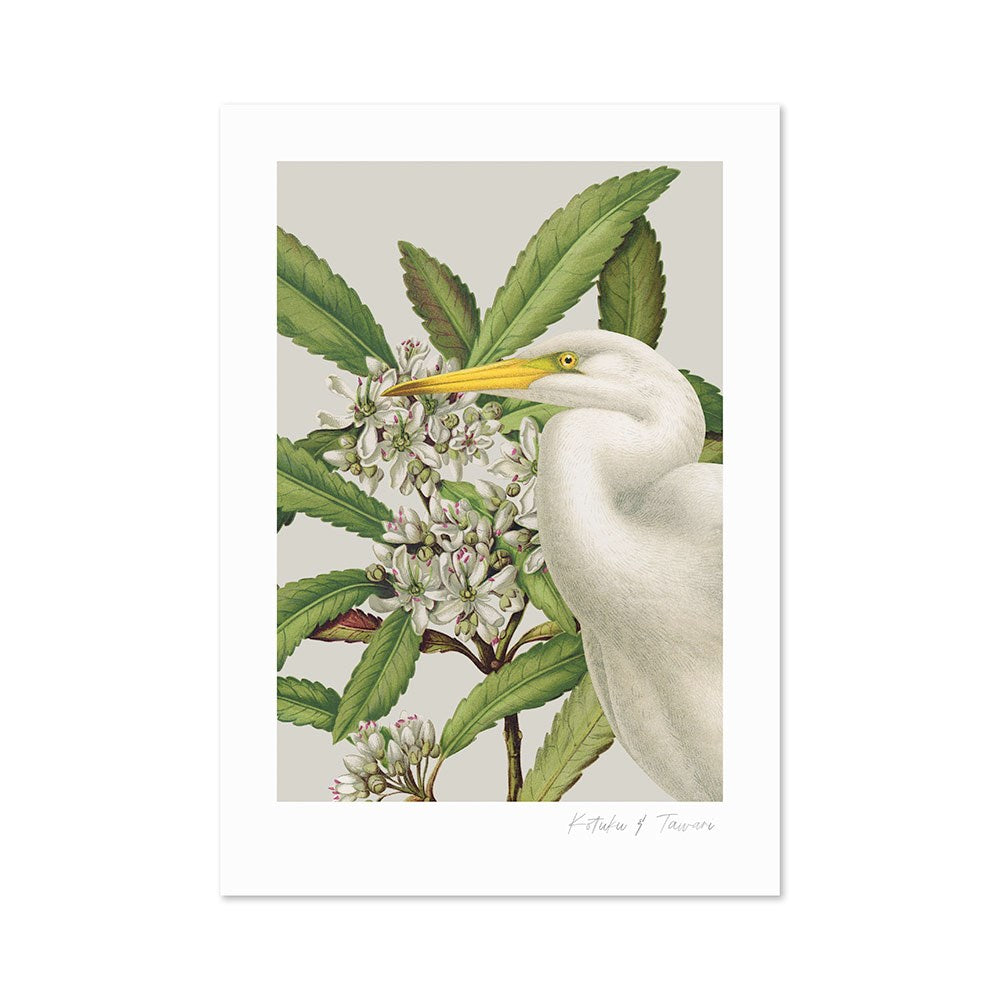 The Birds & Botanics Heron Print features a vintage-style illustration of a white heron standing amid green leaves and white flowers, facing right with its yellow beak raised slightly against a soft, neutral background.