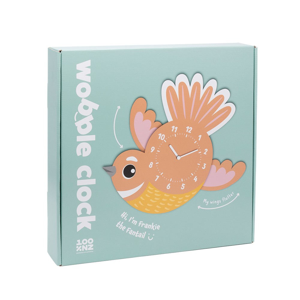 A box featuring the Fantail Kids Wobble Clock, a cartoon bird-shaped wall clock labeled “wobble clock.” The face is on the bird’s body with “Hi, I’m Frankie the Fantail :) My wings flutter.” Displays a New Zealand design on light green.