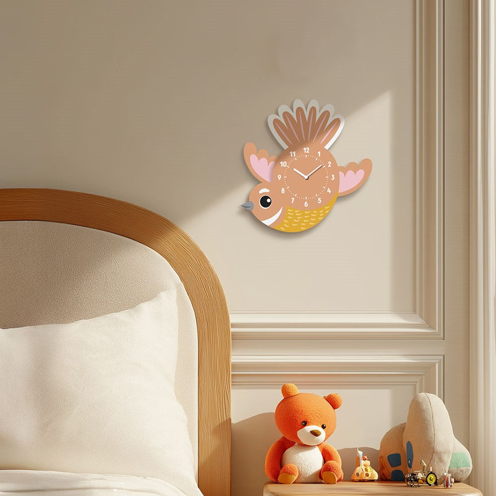 A wooden bed with white bedding sits by a wall featuring a Fantail Kids Wobble Clock. On the bedside table are an orange teddy bear, a blue and beige plush toy, and a small round orange alarm clock.