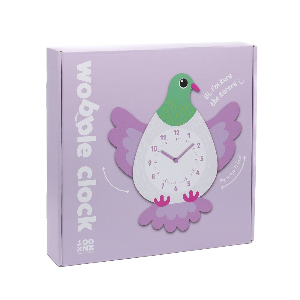 A lavender box features the Kereru Kids Wobble Clock, shaped like a cartoon New Zealand Kererū with purple wings and pink feet. “Wobble Clock” and “Hi! I’m Kura the Kererū :)” are printed on the centered display.