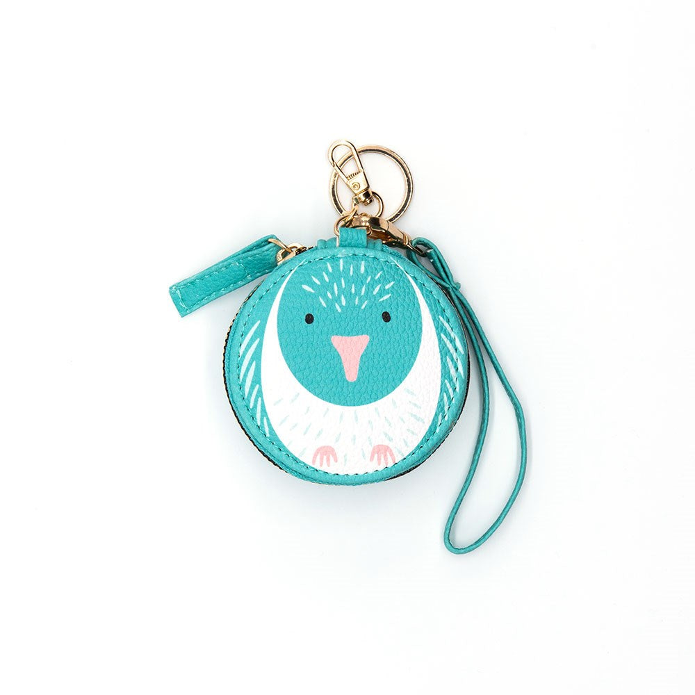 The Kereru Cutie Coin Purse is a round turquoise purse with a bird face, pink beak, and white chest. It includes a matching wrist strap and gold keyring—ideal for bird lovers and style enthusiasts on the move.