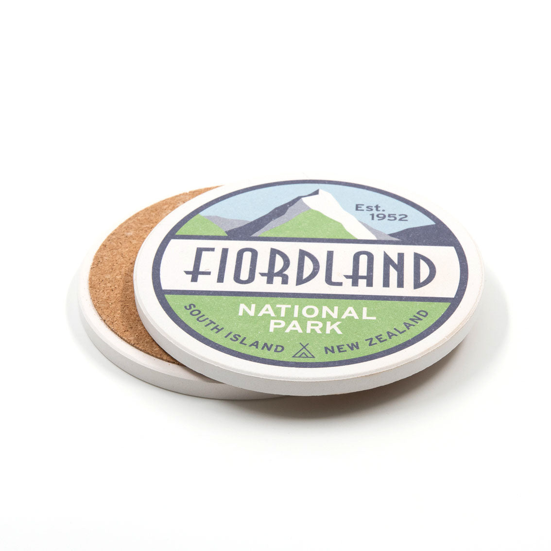 A set of 4 round National Park coasters featuring “Fiordland National Park, South Island, New Zealand, Est. 1952” with a mountain and lake design, cork backing, and white edges.