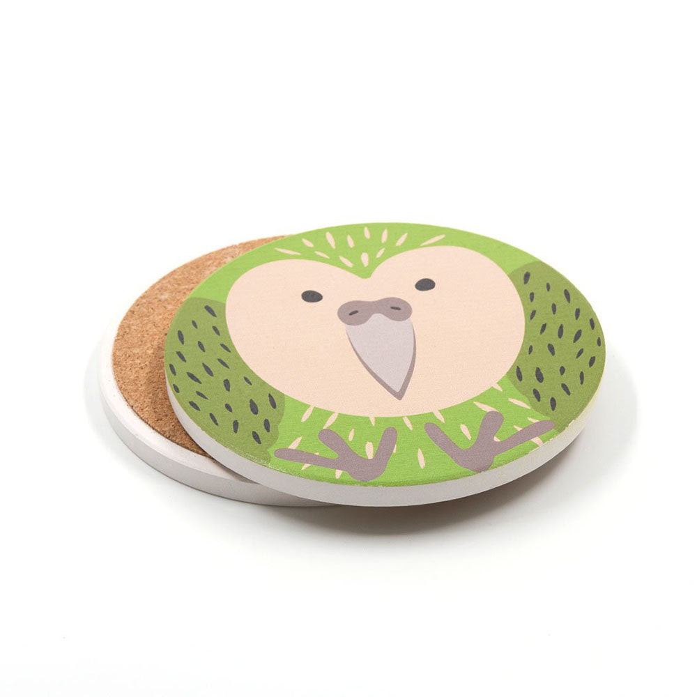 A set of 4 ceramic coasters with cork bases, each featuring a cute cartoon green and white Kiwi bird with small wings and a big beak—perfect for bird lovers or New Zealand-themed gift collections.