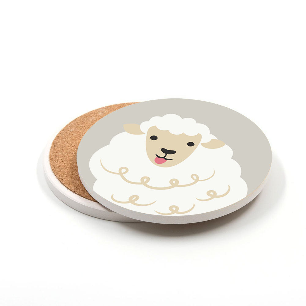 The Set of 4 Storybook Ceramic Coasters features round ceramic coasters with cork bases, each displaying a cheerful New Zealand-style cartoon sheep on a gray background. The photo shows one coaster partly overlapping another identical one.