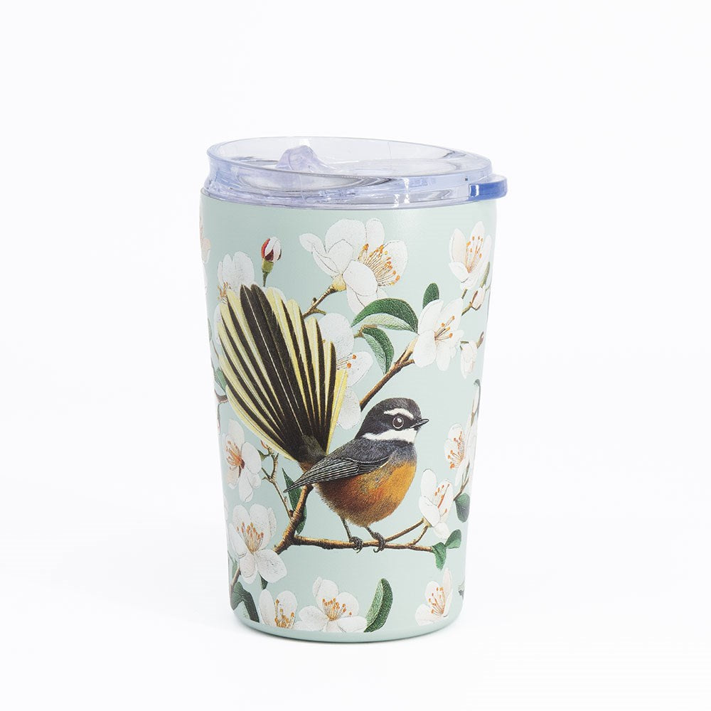 Introducing the Chatty Fantail Coffee Cup—a light blue, vacuum insulated stainless steel travel mug featuring a clear, spill-resistant lid. Adorned with delicate white blossoms and a beautifully detailed illustration of a small fantail bird with a fanned tail perched on a branch, this cup blends charming design with practical durability for all your adventures.