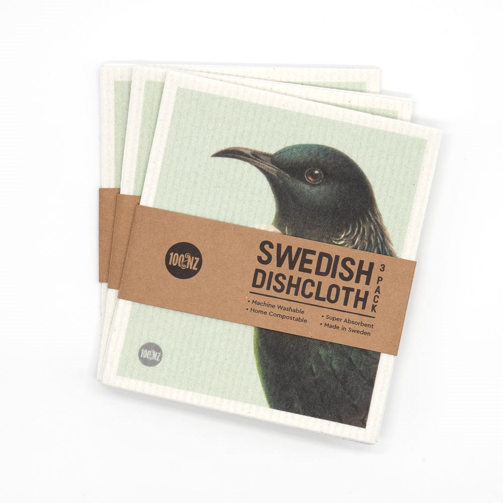A set of three eco-friendly Swedish Dishcloths - Hushed Birds, featuring charming bird illustrations, wrapped in a brown paper band labeled "Swedish Dishcloth 3 Pack" with product details.