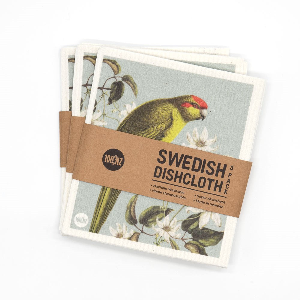 Three Swedish Dishcloths - Birds & Botanicals, featuring eco-friendly bird and floral designs, come in a brown paper wrap labeled Swedish Dishcloth 3 Pack. The label highlights that they're machine washable, super absorbent, and home compostable.