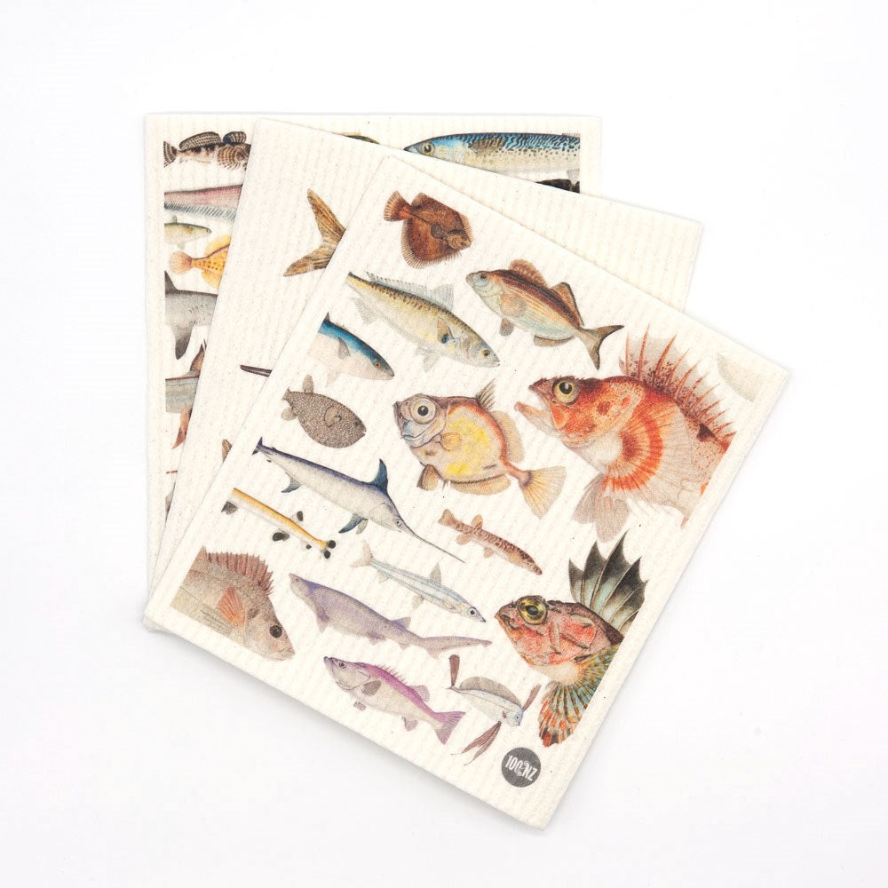 Two eco-friendly Swedish Dishcloths - Fishes of NZ, each featuring illustrated fish species in different sizes and colors. One cloth with colorful Kiwiana images partially overlaps the other, both set against a white background.