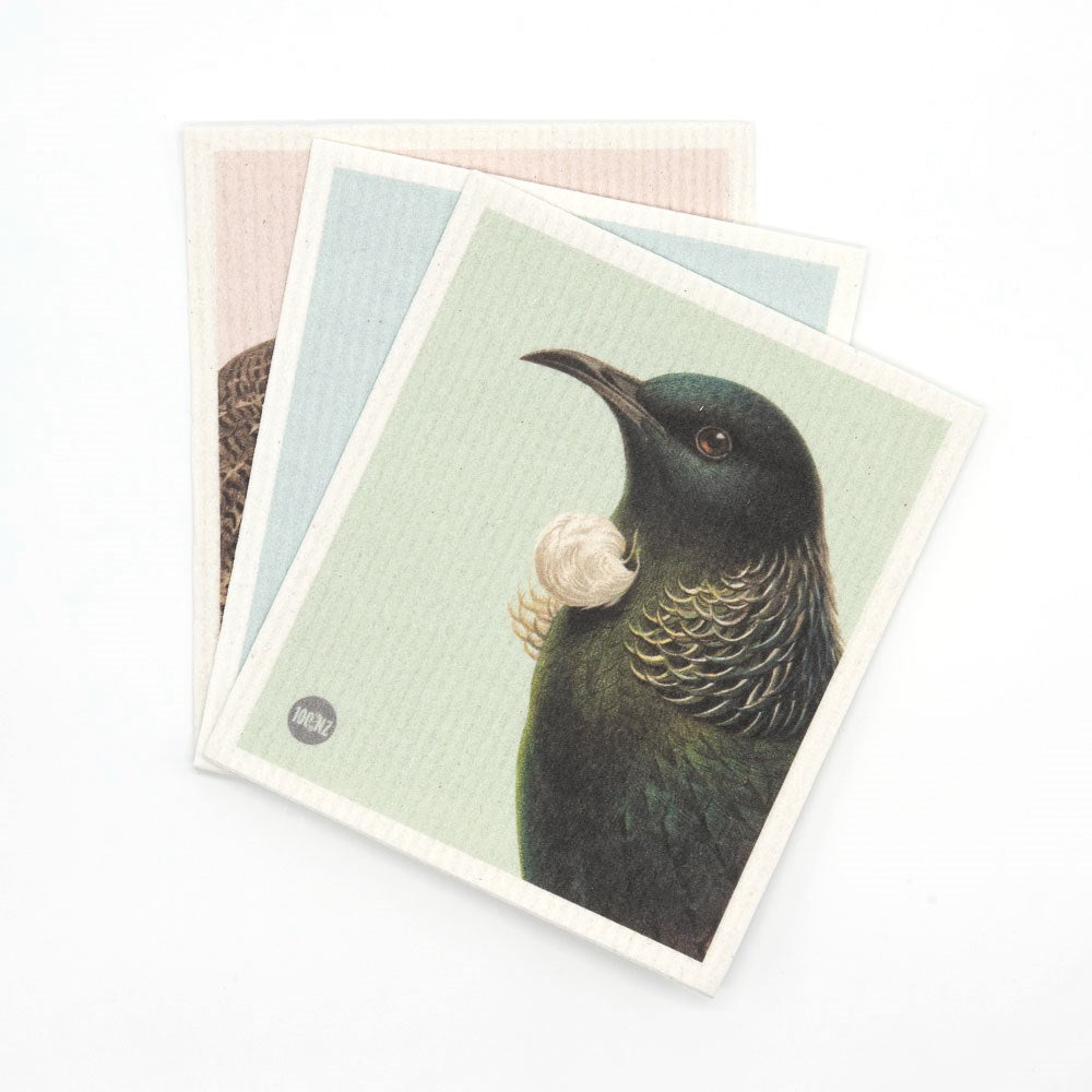 Three illustrated Swedish Dishcloths - Hushed Birds feature Kiwiana bird designs, including a detailed tui on pale green. The slightly fanned dishcloths on a white surface add an eco-friendly touch to your home.