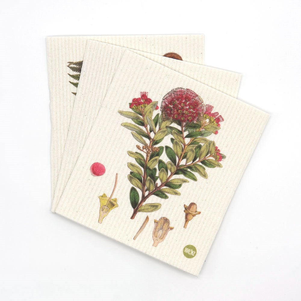 Two eco-friendly, reusable Swedish Dishcloths - Botanical Illustrations are stacked, each off-white and textured with prints of green leaves, red blooms, stems, a seed pod, and a pink accent.