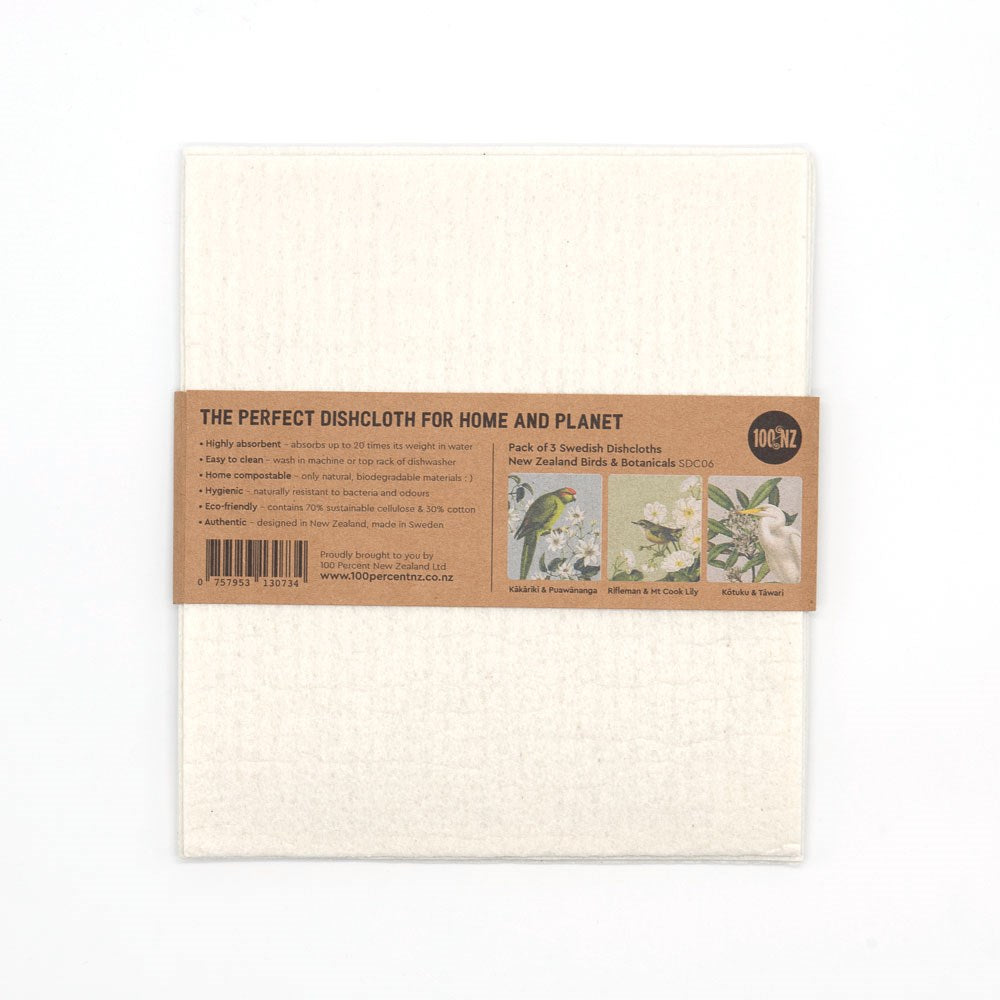 The Swedish Dishcloths - Birds & Botanicals pack includes three white eco-friendly cloths with Kiwiana-inspired birds and flowers. The brown paper label details features, care instructions, and highlights the sustainable design.