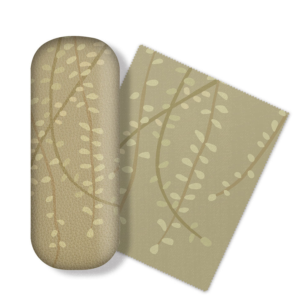 The Raw Kowhai Glasses Case includes a tan oval case with rounded edges and a matching rectangular microfibre cloth. Both feature pale, vine-inspired lines and leaves reflecting New Zealand flora—ideal for cleaning glasses and screens.