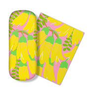 The Bright Botanical Kowhai Glasses Case, with a yellow flower and green stem pattern on pink, comes with a matching microfibre cloth. Both are ideal for cleaning glasses or screens and are shown side by side on a white surface.