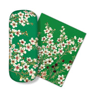 The Manuka Flower Glasses Case includes a green case and matching micro-fibre cloth featuring white and pink cherry blossoms with green leaves, perfect for cleaning glasses or screens. Both have a plain white background.