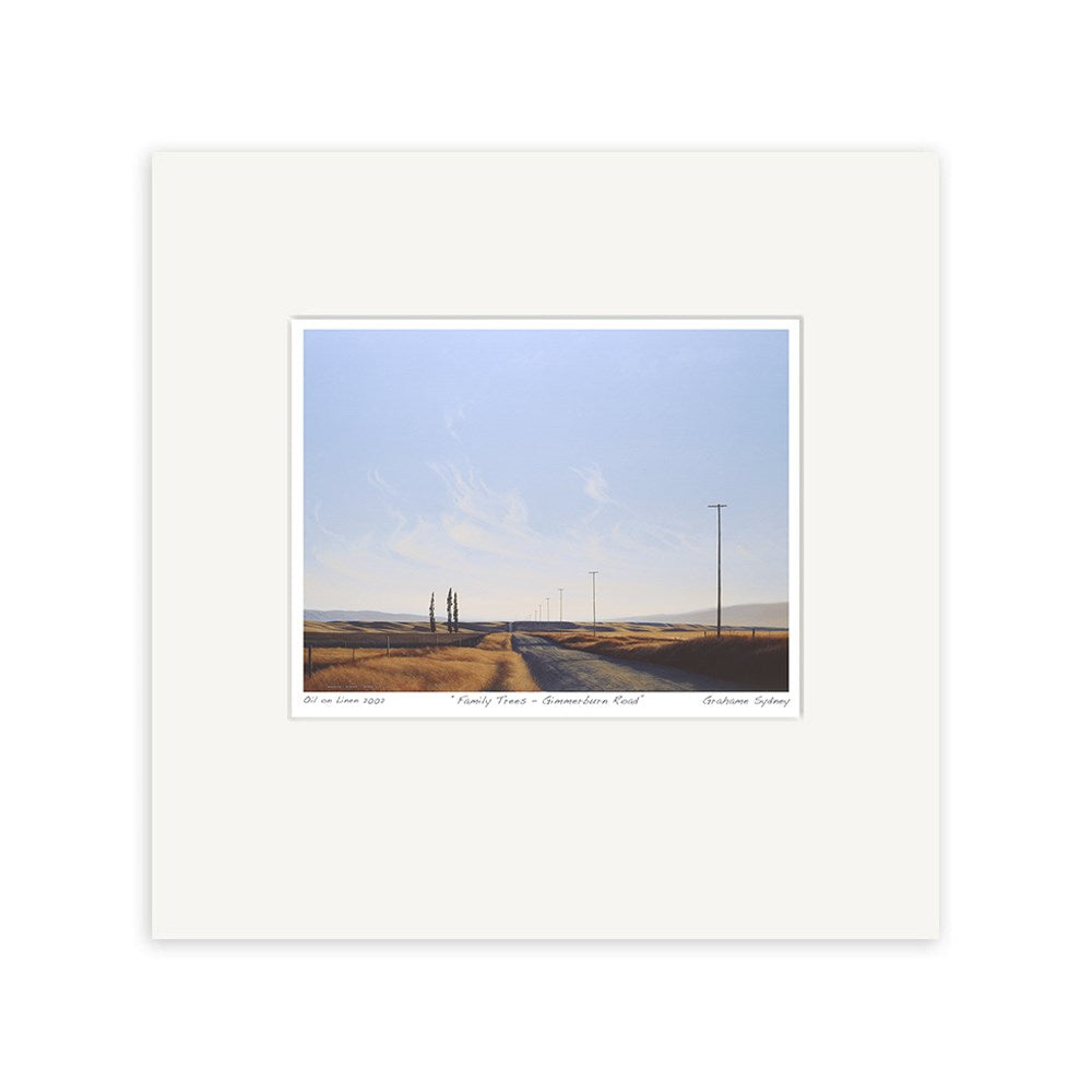 The "Grahame Sydney - Family Trees, Gimmerburn Road Small Art Print" features a rural road with utility poles, golden fields, and distant trees under a clear sky, centered in a wide white mat—capturing the essence of New Zealand landscapes.