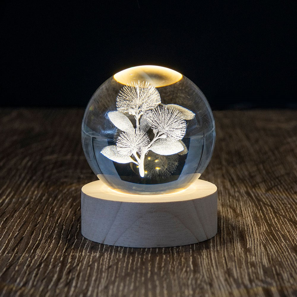 The Pohutukawa LED Globe features a clear glass sphere with a 3D laser-engraved New Zealand Christmas tree, set on a round wooden base and softly illuminated from below.