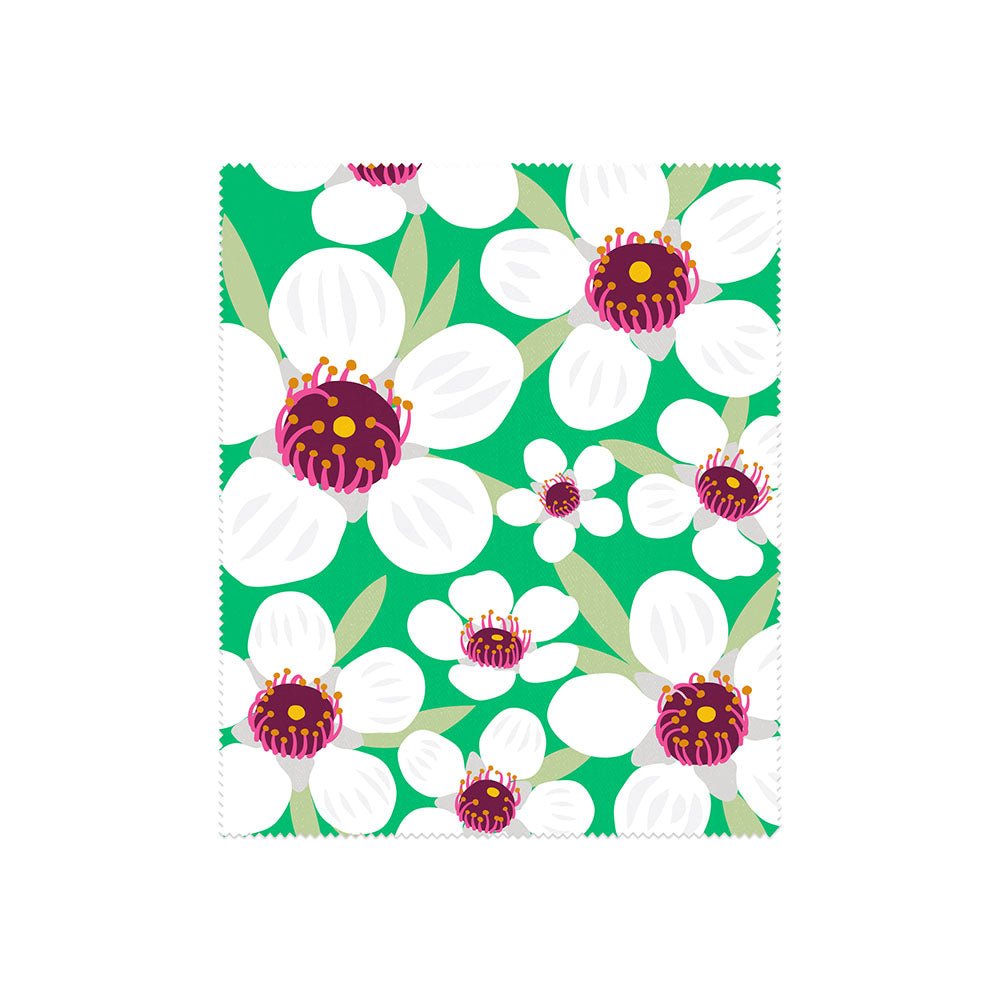 Part of our Set of 4 Bright Botanical Collection Lens Cloths, this rectangular cloth showcases large white flowers with purple and yellow centers, green leaves on a green background, and zigzag-cut edges.