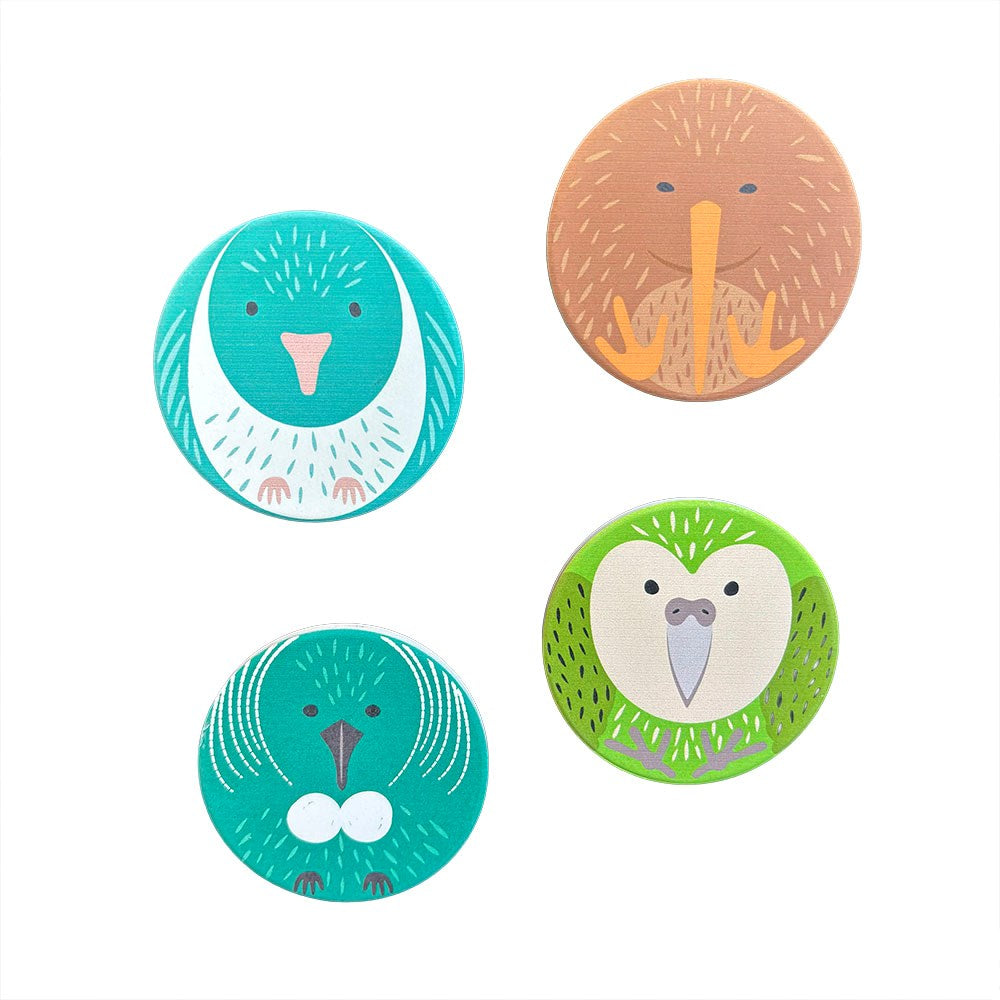 The NZ Cuties Ceramic Magnet Set features four round ceramic magnets with cute bird faces in teal, brown, and green, arranged in a square on white—perfect as fridge magnets and printed in New Zealand.