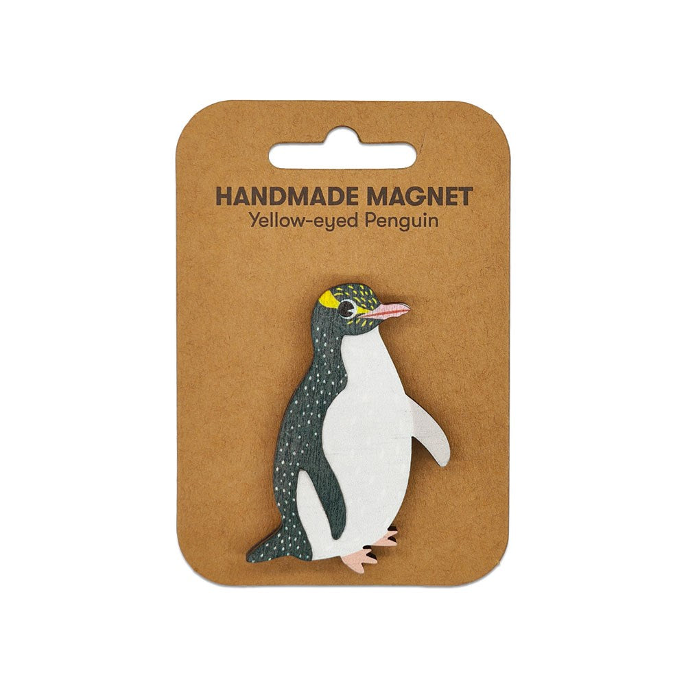 A small handcrafted Yellow-eyed Penguin Wooden Magnet is attached to a brown card labeled “Handmade Magnet Yellow-eyed Penguin” in black text.