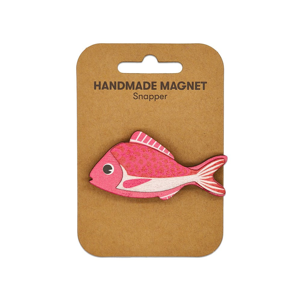 A pink fish-shaped Snapper Wooden Magnet is attached to a brown backing card with a cutout for hanging.