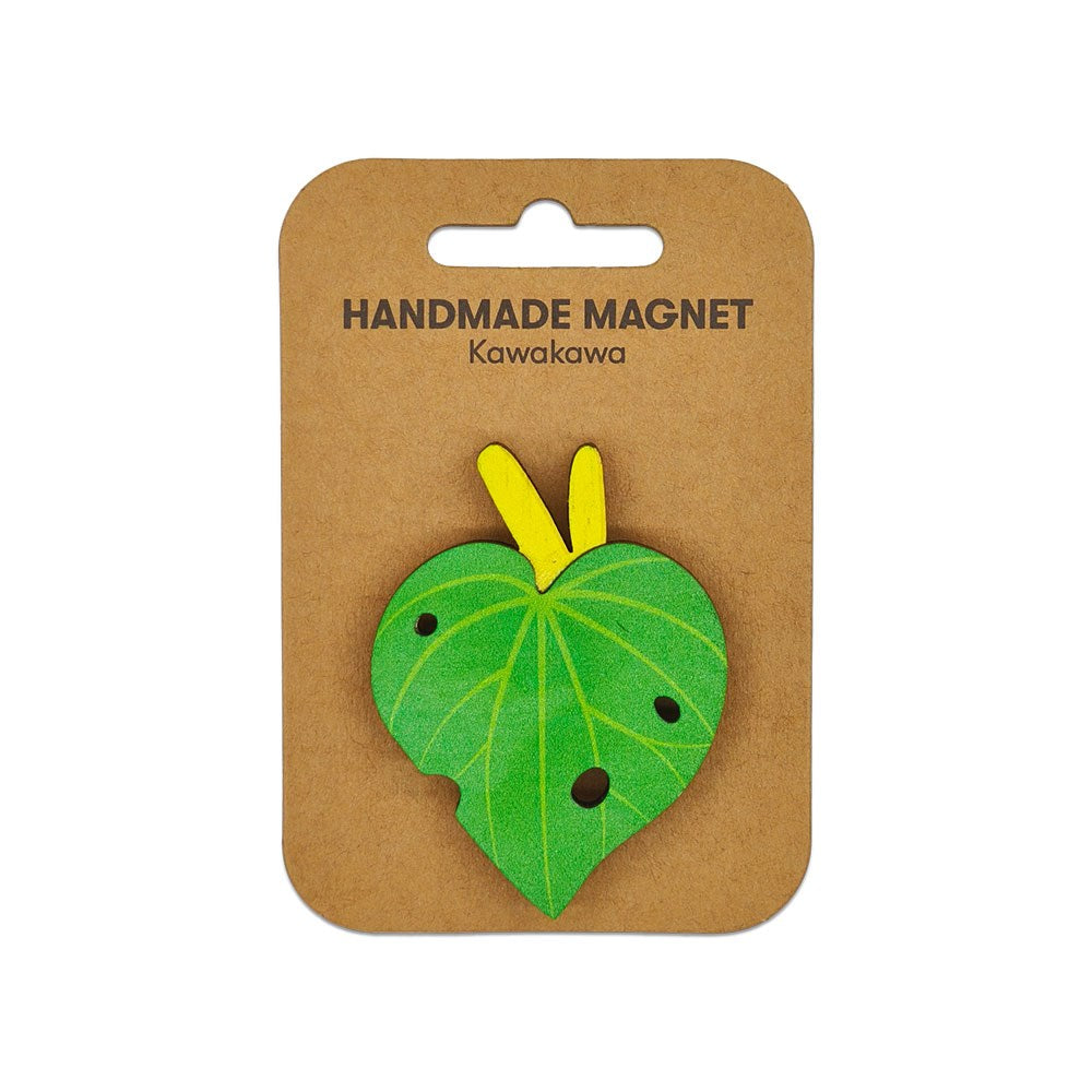 The Kawakawa Wooden Magnet is a handmade wooden magnet with a kawakawa design, yellow stems, and dark spots, attached to a brown card labeled HANDMADE MAGNET Kawakawa—a unique Kiwiana addition to your collection.