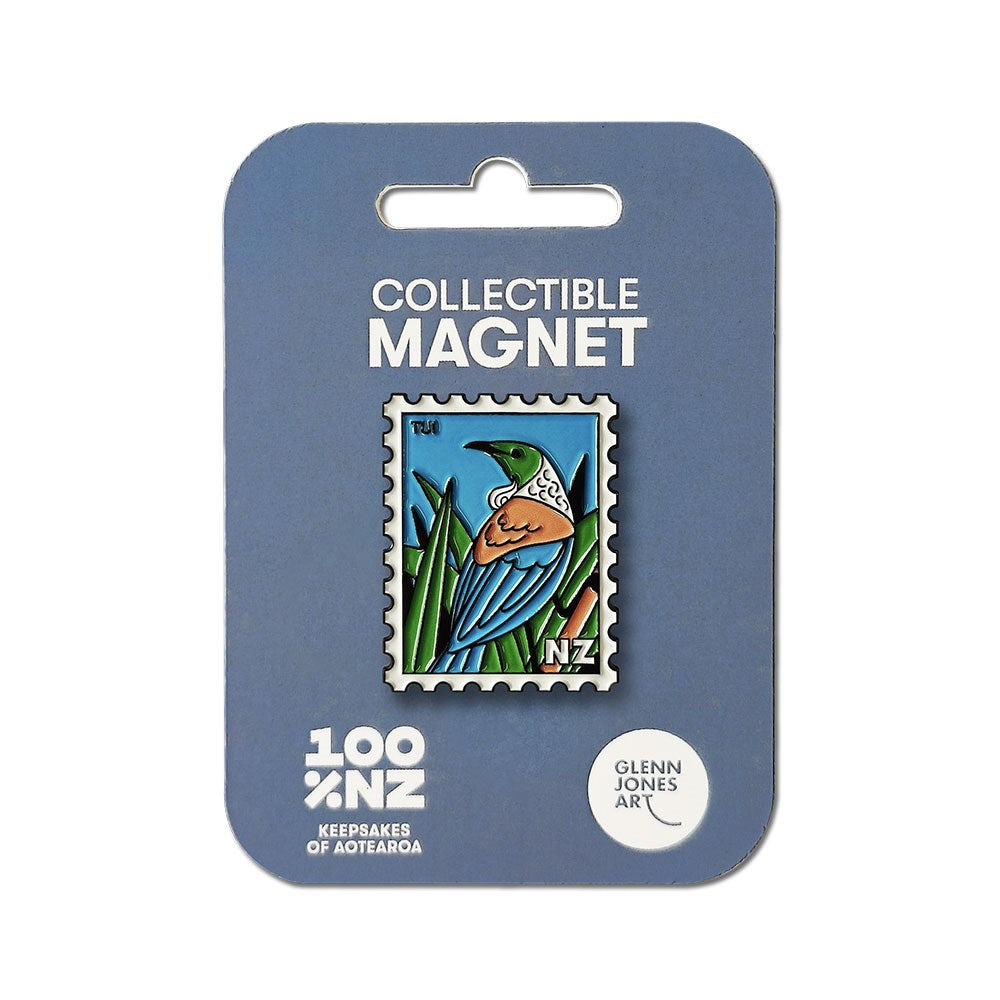 The Tui Collectible Stamp Magnet features a vibrant bird design, created in New Zealand. It comes on blue packaging marked “Collectible Magnet—100% NZ—Keepsakes of Aotearoa—Glenn Jones Art.”.