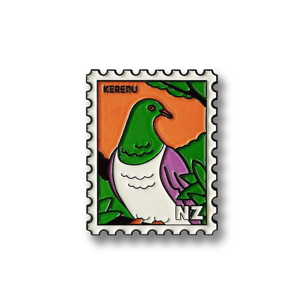 The Kereru Collectible Stamp Magnet features Glenn Jones Artwork of a kererū bird with a green head, white belly, and purple wings on an orange background with green leaves, labeled KERERU and NZ—a unique collectible.