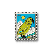 Illustration of a New Zealand postage stamp featuring a green kea parrot, mountains, and a yellow sun—this Kea Collectible Stamp Magnet, inspired by Glenn Jones Artwork, has KEA and NZ in the corners for fans to enjoy.