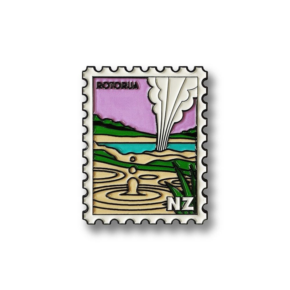 The Rotorua Collectible Stamp Magnet features stylized artwork of a geyser erupting and geothermal pools under a purple sky, with ROTORUA and NZ text, capturing the regions natural beauty.